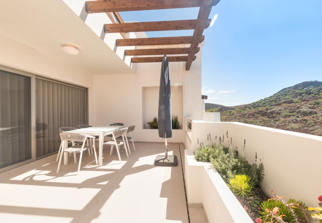 Amplia terraza con mesa para comer y zona de hamacas