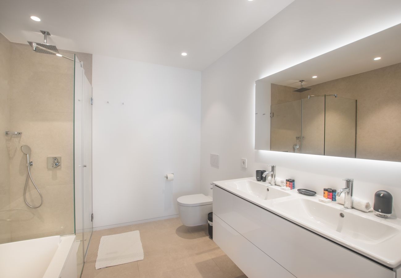 Spacious bathroom with bath and floor-level walk-in shower