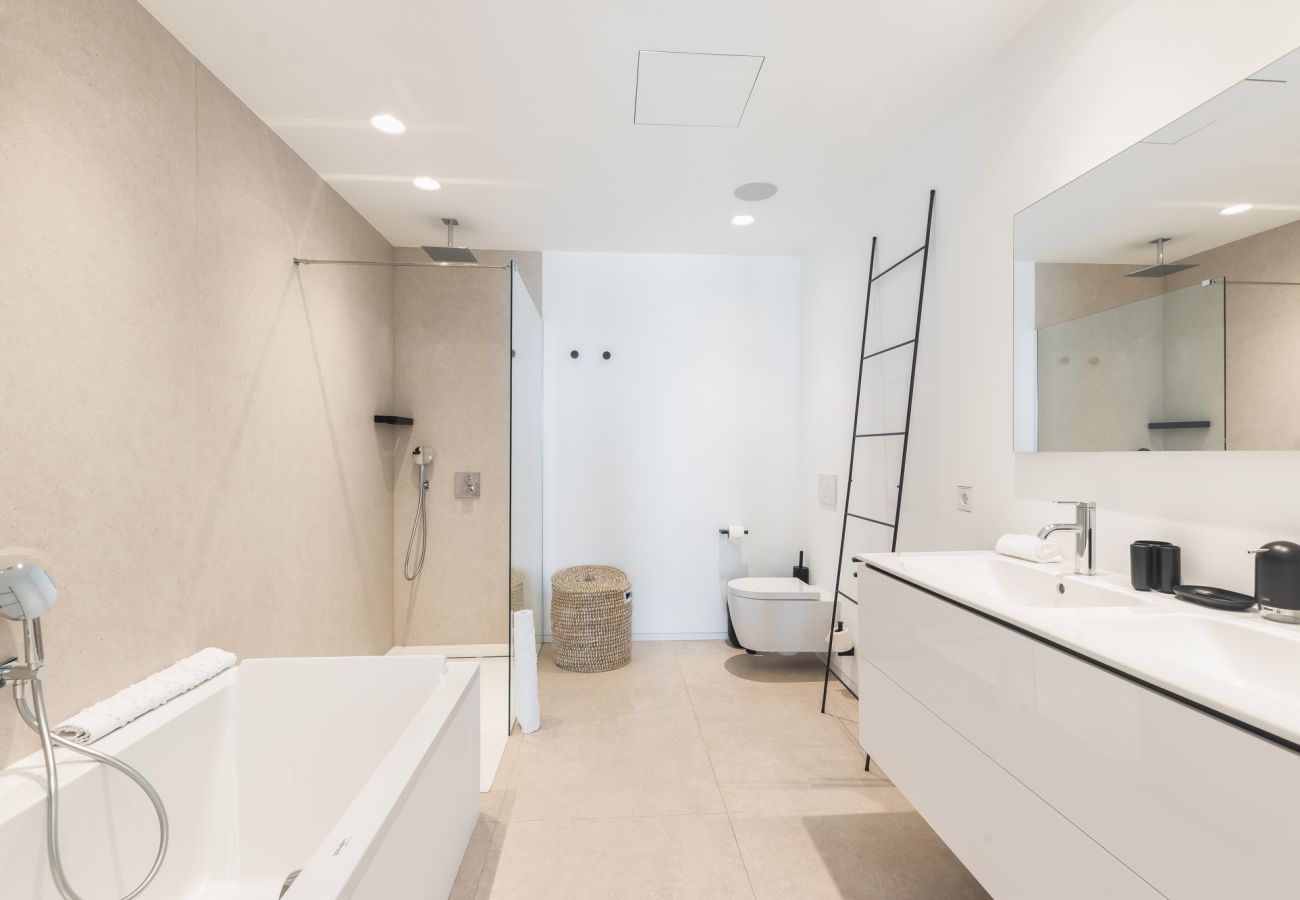 Spacious bathroom with bath and floor-level walk-in shower