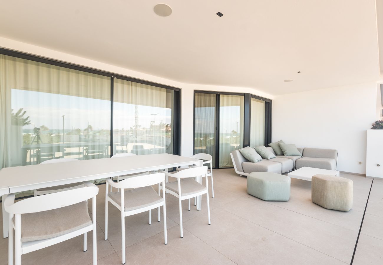 Grande terrasse avec coin détente et table à manger vue mer.